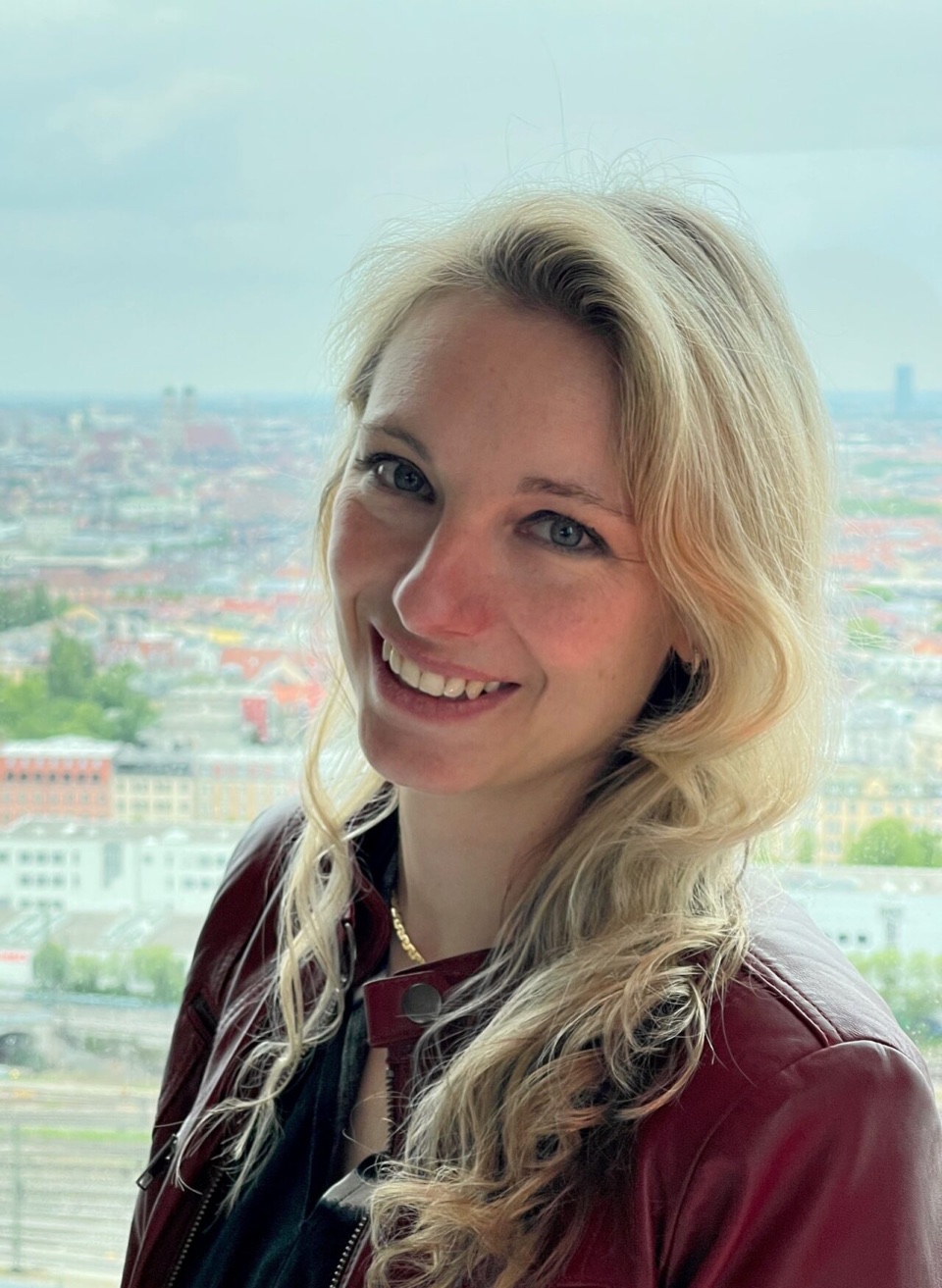 Porträt von Prof. Dr. Sandra Niedermeier vor einem Stadtpanorama